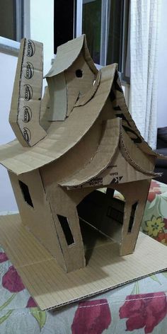 a cardboard birdhouse made to look like a house