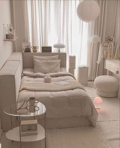 a white room with a bed, couch and table