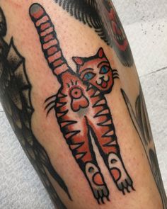 a close up of a person's leg with a cat tattoo on it