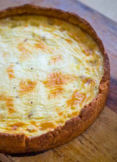 a quiche sitting on top of a wooden cutting board