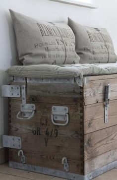 an old trunk turned chair with pillows on top