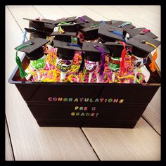 graduation caps and confetti in a black box with congratulations written on the side