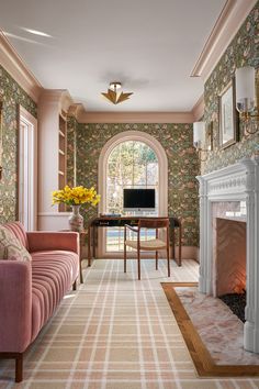 a living room filled with furniture and a fire place in front of a large window