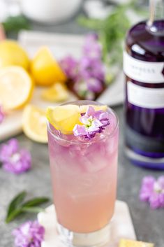 a pink drink with lemon and purple flowers