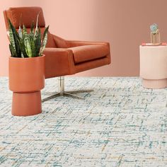 a living room with a chair, plant and rug on the floor in front of it