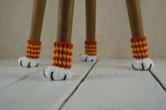 two wooden poles with knitted feet on them