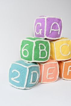 crocheted alphabet blocks stacked on top of each other with the letters written in them