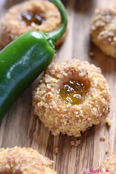 some food on a wooden table with a green pepper in the middle and other foods around it