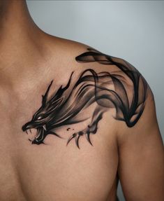 a man's chest with a black dragon tattoo on it