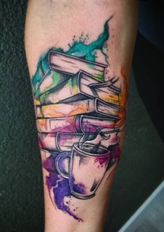 a tattoo with books and a cup on it