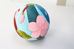 a blue and pink flowered ball sitting on top of a white table next to a wall