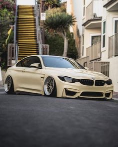 a white car parked on the street next to some stairs