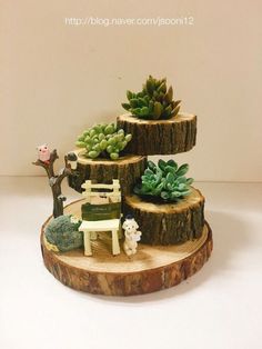 three tiered planter with succulents and miniature animals on it's sides