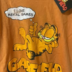 an orange t - shirt with a cartoon cat saying i love mental games on it