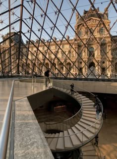 the inside of a glass building with a spiral stair case in it's center