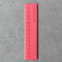 a pink ruler sitting on top of a cement floor