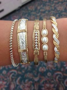 several different types of bracelets are on someone's arm, both with pearls