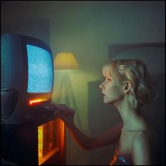 a woman is looking at an old tv