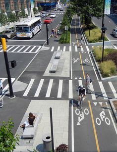 an aerial view of a city street with people riding bikes and walking on the sidewalk