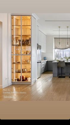 an open cabinet in the middle of a kitchen with lots of counter space and shelves