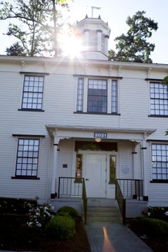 the sun shines brightly in front of a white building