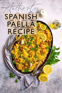 a pan filled with rice and peas next to lemon wedges on top of a table