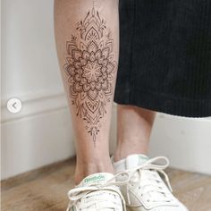 a woman's leg with a tattoo on it and a pair of white tennis shoes