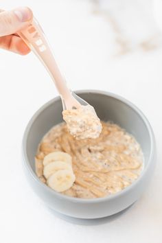 a person holding a spoon full of oatmeal with bananas and peanut butter