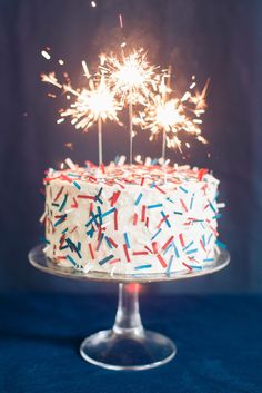 a birthday cake with sprinkles and sparklers