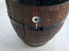 a wooden barrel sitting on top of a white floor next to a metal door handle