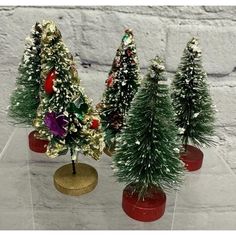 three small christmas trees sitting on top of a table