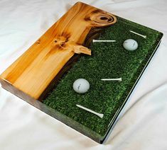 a wooden box with golf balls and tees in it on a white sheet background