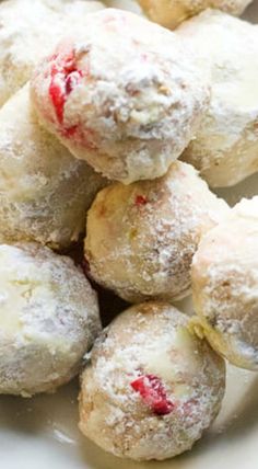 powdered sugar covered doughnuts on a white plate with raspberry filling