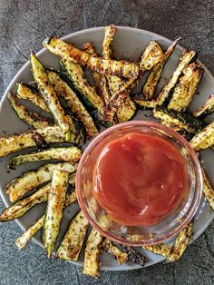 grilled asparagus on a plate with ketchup in a glass bowl