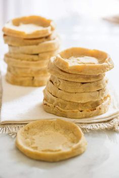 a stack of pancakes sitting on top of a white cloth next to a cupcake