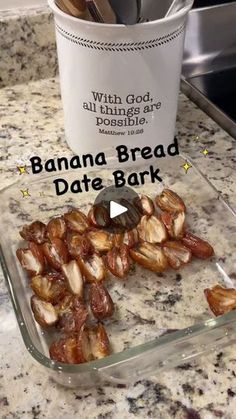 bananas and dates in a glass dish with spoons on the counter next to a coffee mug