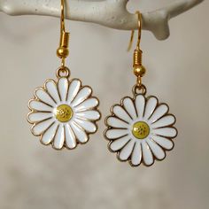 Make a statement with these pretty daisy flower drop earrings for women. These cool quirky gold plated and enamel daisy earrings are a great way to add a nice touch to your outfit. The charm on these daisy dangle earrings measures at 2.1cm x 1.8cm and is attached to a gold plated hook. Please feel free to get in touch with us at Funky Earrings UK if you have any questions. We also have a wide range of other cute and unusual earrings in our shop. Metal Flower Charm Earrings For Spring, Gold Flower Charm Earrings For Summer, White Flower-shaped Jewelry With Sunflower Design, White Flower Jewelry With Sunflower Design, White Sunflower Design Flower Jewelry, Gold Enamel Earrings With Flower Charm, Gold Earrings With Flower Charm In Enamel, Gold Earrings With Flower Charm And Enamel, Summer Flower Shaped Metal Earrings