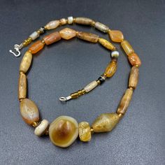 The beautiful mala necklace consist of Himalayan luk Mik or we called them magic eye bead as well in the center of the mala necklace with Banded Agate ,carnelian . Luk Mik means (Goat's eyes) in Tibetan Natural found from Himalaya Tibet dating more than 1000 yrs. The origin of this beads from Himalaya Tibet but also can found in India, Nepal and Pakistan too They were used as a special charm Jewelry and amulet at that time period very good condition They were used in prayers mala and used as amu Spiritual Amber Gemstone Necklace, Rituals Natural Stones Beaded Necklaces With Round Beads, Amber Agate Hand-strung Jewelry, Ritual Beaded Necklaces With Natural Stones, Spiritual Amber Beaded Necklaces With Large Beads, Healing Agate Necklaces With Polished Beads, Amber Natural Stone Necklace, Spiritual Amber Necklace For Healing, Amulet Style Hand-strung Necklaces With Oval Beads