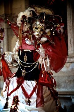 a woman dressed in red and white is posing for the camera with her mask on