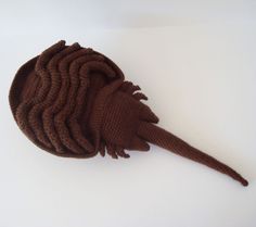 a brown knitted animal head laying on top of a white surface