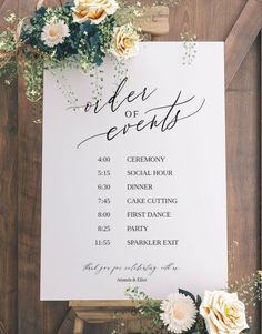 a sign with flowers and greenery on it next to a wooden frame that says order of events