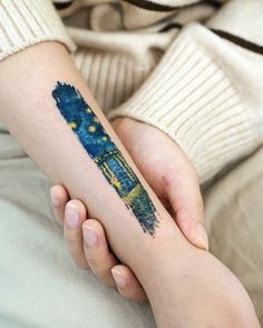 a person holding their arm with a tattoo on it