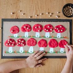 someone is making a mushroom craft with red and white doughnuts on the table