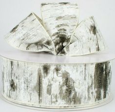 a white and black ribbon on top of a roll of silver metallic foiled paper