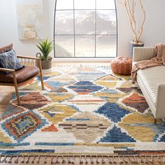 a living room with a couch, chair and rug in front of a large window