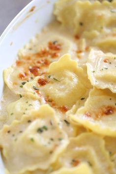 a white plate topped with ravioli and cheese