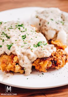 a white plate topped with meat covered in gravy