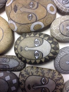 some rocks with different designs on them and one has a face painted on the rock