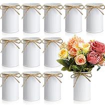 a bunch of white jars with flowers in them