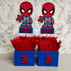 there are two spiderman cupcake toppers in the same blue box with red paper straws